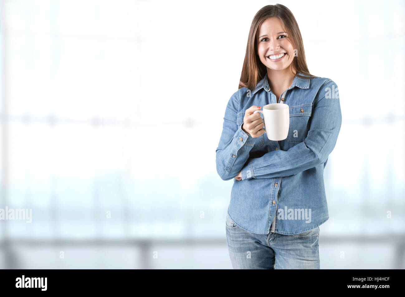 Donna odore di una tazza di caffè, pronto a bere in un ufficio Foto Stock