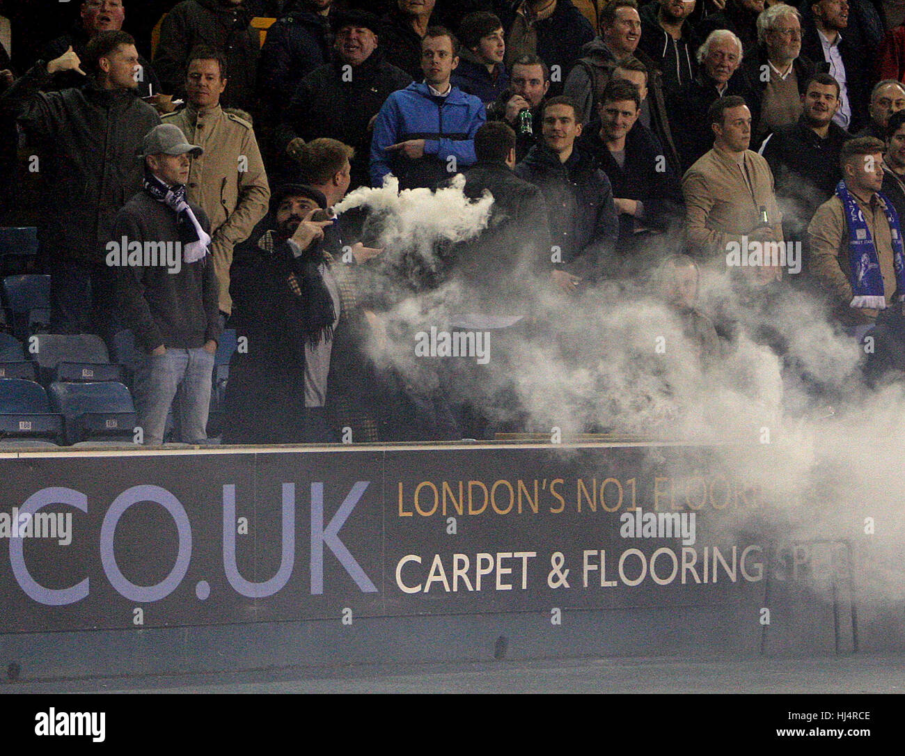 Un Millwall F.C. appassionato di calcio rende la luce di un incidente in cui un Charlton Athletic sostenitore ha gettato un barattolo di fumo verso il Millwall fan. Il pensiero veloce sostenitore prelevato il barattolo di vernice e pretendeva di fumi da esso come se fosse un sigaro, causando il tifo e risate dai suoi compagni seduti intorno a lui. Millwall F.C. beat Charlton Athletic 3-1 al Den. Dotato di: Millwall ventola con bomba di fumo dove: Londra, Regno Unito quando: 22 Dic 2016 Credit: WENN.com Foto Stock