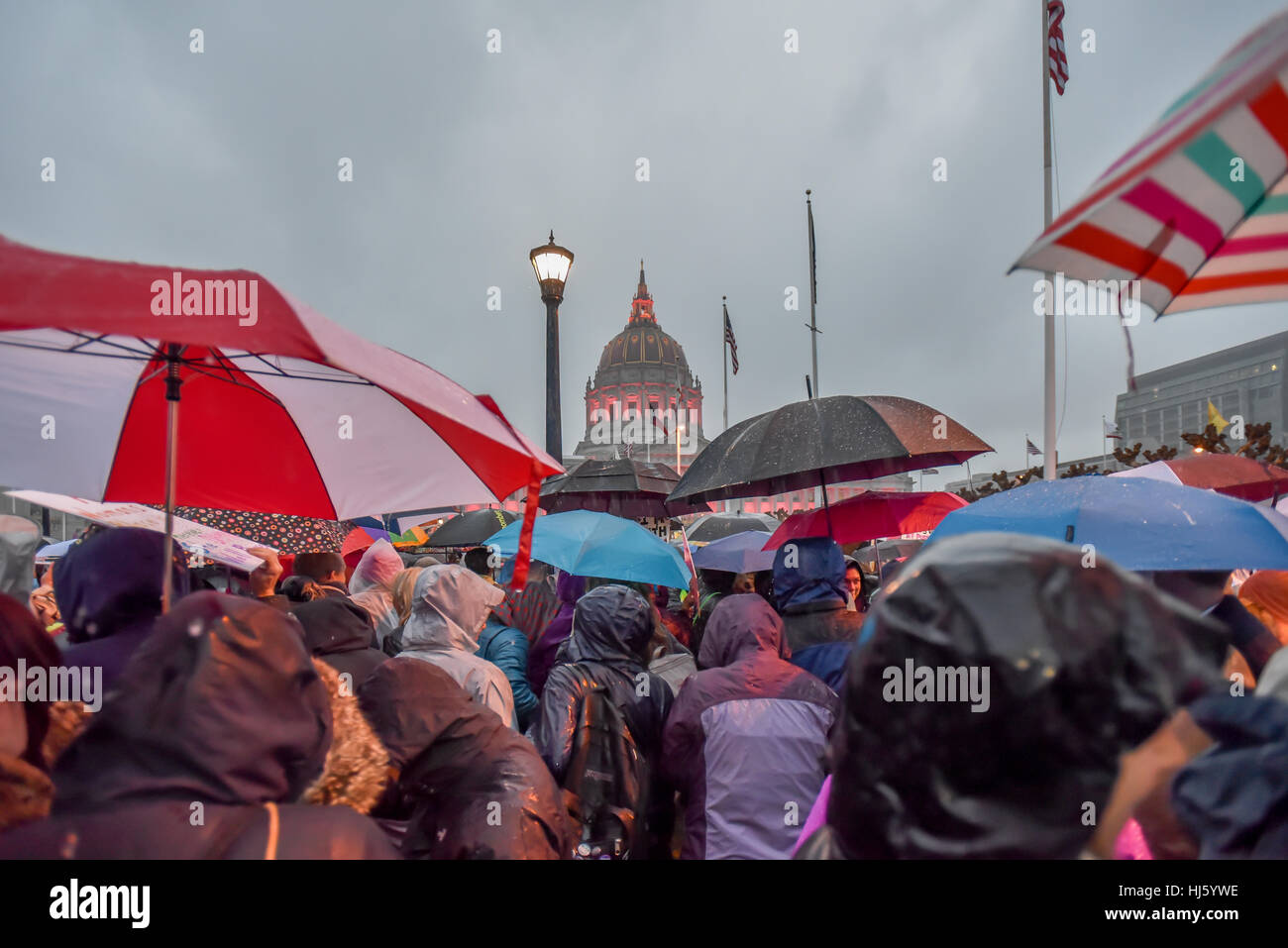 San Francisco, California, Stati Uniti d'America. Il 21 gennaio, 2017. San Francisco, serata di donne a marzo 2017 dopo Trump inaugurazione con il municipio di rosa e molti spettatori con ombrelloni in caso di pioggia. Credito: Shelly Rivoli/Alamy Live News Foto Stock
