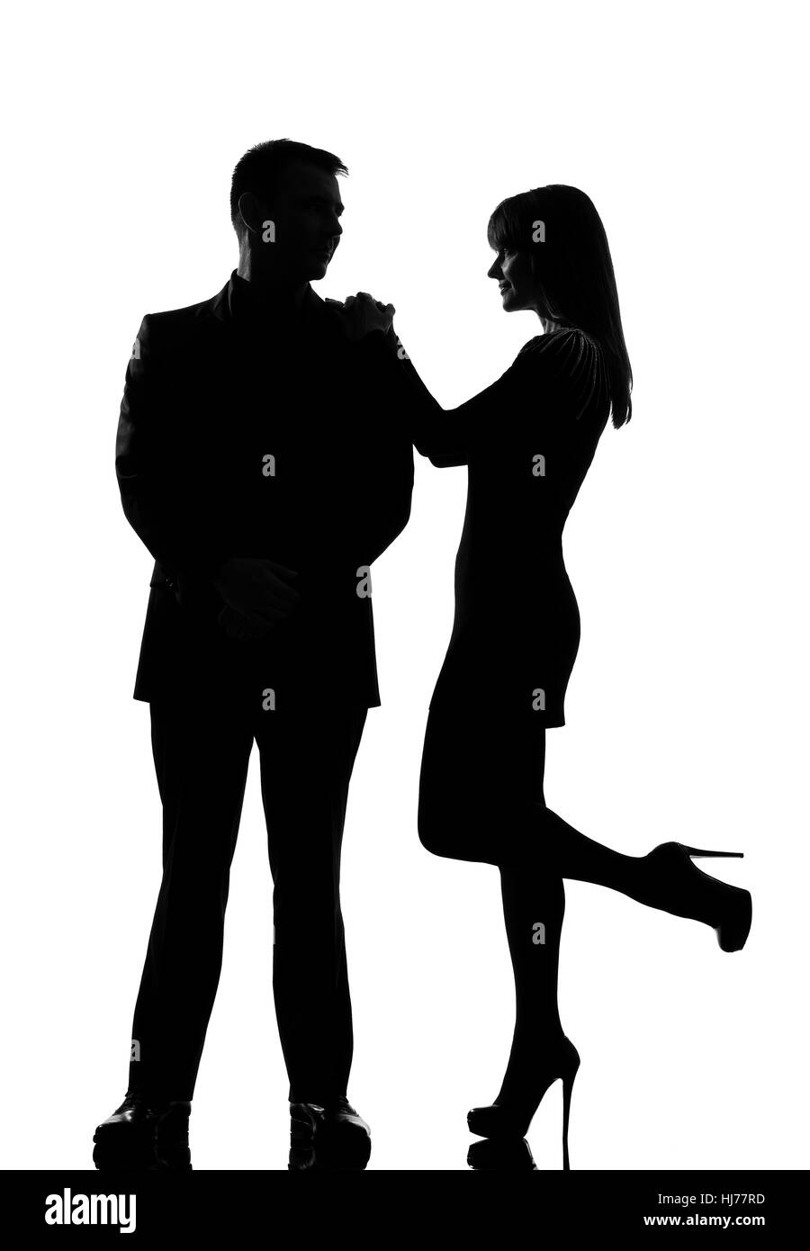 Un caucasian giovane uomo e donna in piedi faccia a faccia sorridente in studio silhouette isolati su sfondo bianco Foto Stock