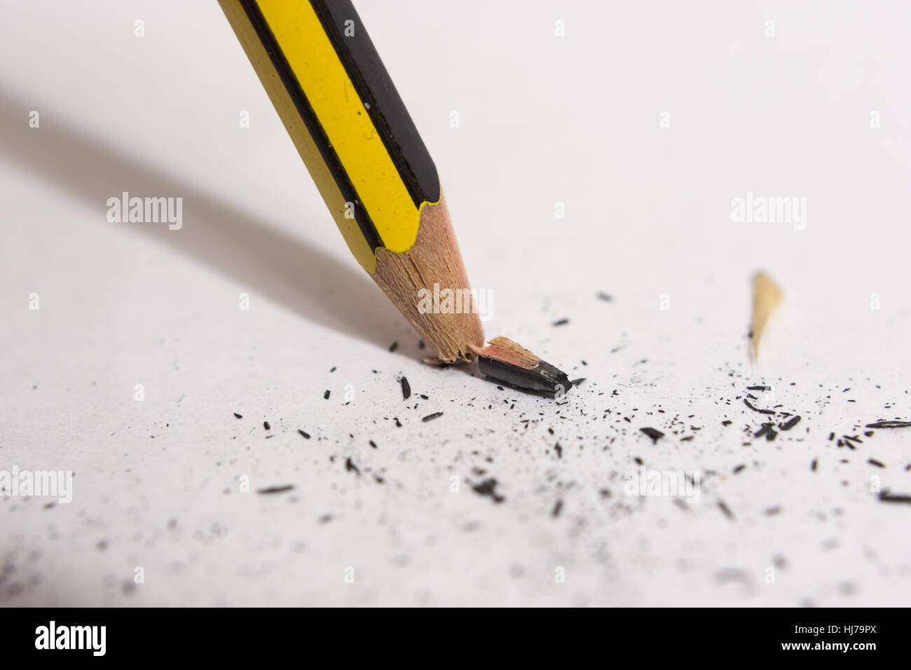 Scatto e rotture di punta di matita contro un foglio di carta Foto Stock
