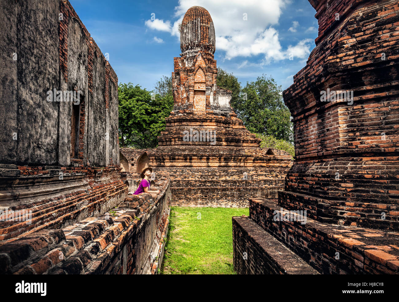 Donna in hat guardando antichi una città in rovina in Lopburi, Thailandia Foto Stock