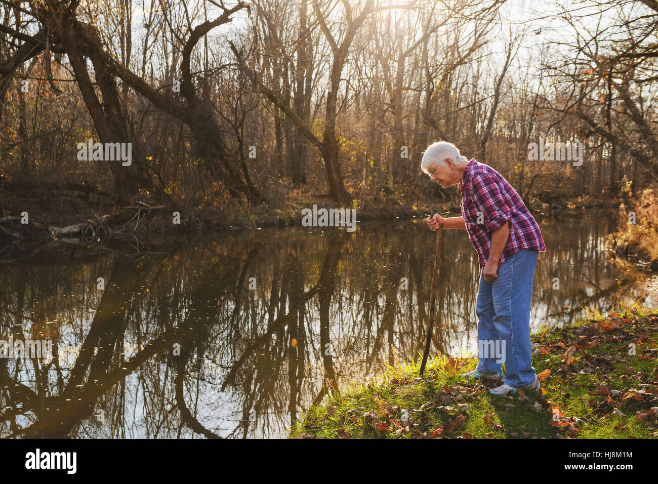 Senior donna cercando in fiume Foto Stock
