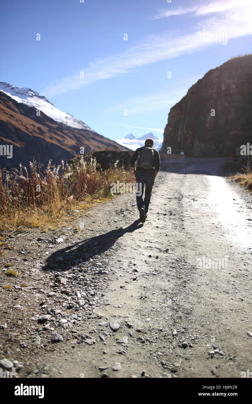 Uomo che cammina lungo un sentiero di montagna, Svizzera Foto Stock