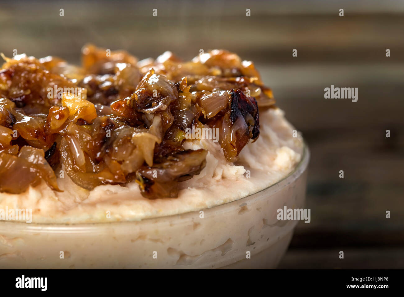 Purea di Fagioli con cipolla fritti o Iahnie - rumeno tradizionale cibo su sfondo di legno Foto Stock