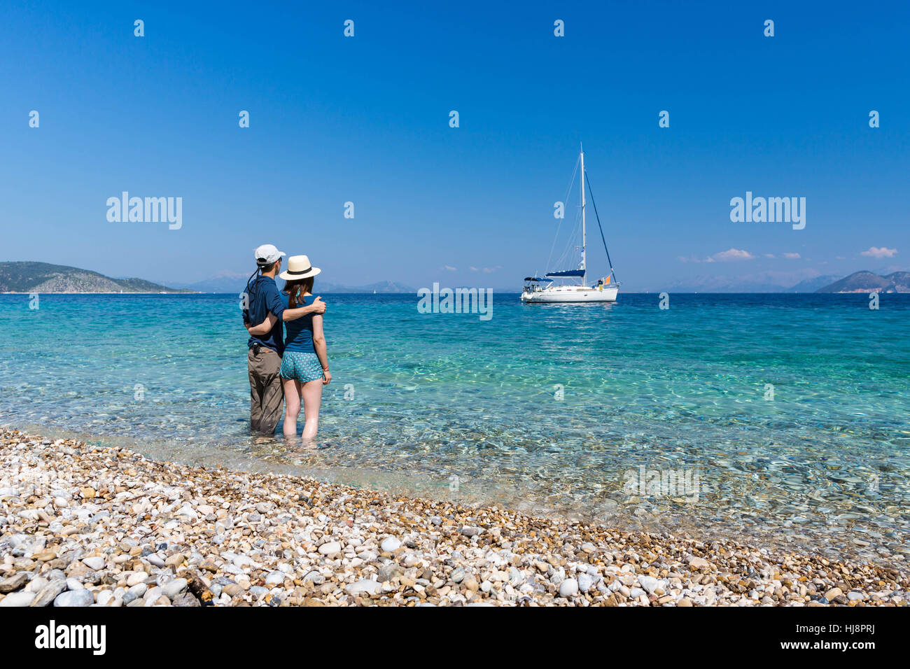 Matura in piedi in mare con le braccia intorno a ciascun altro, Itaca, Grecia Foto Stock