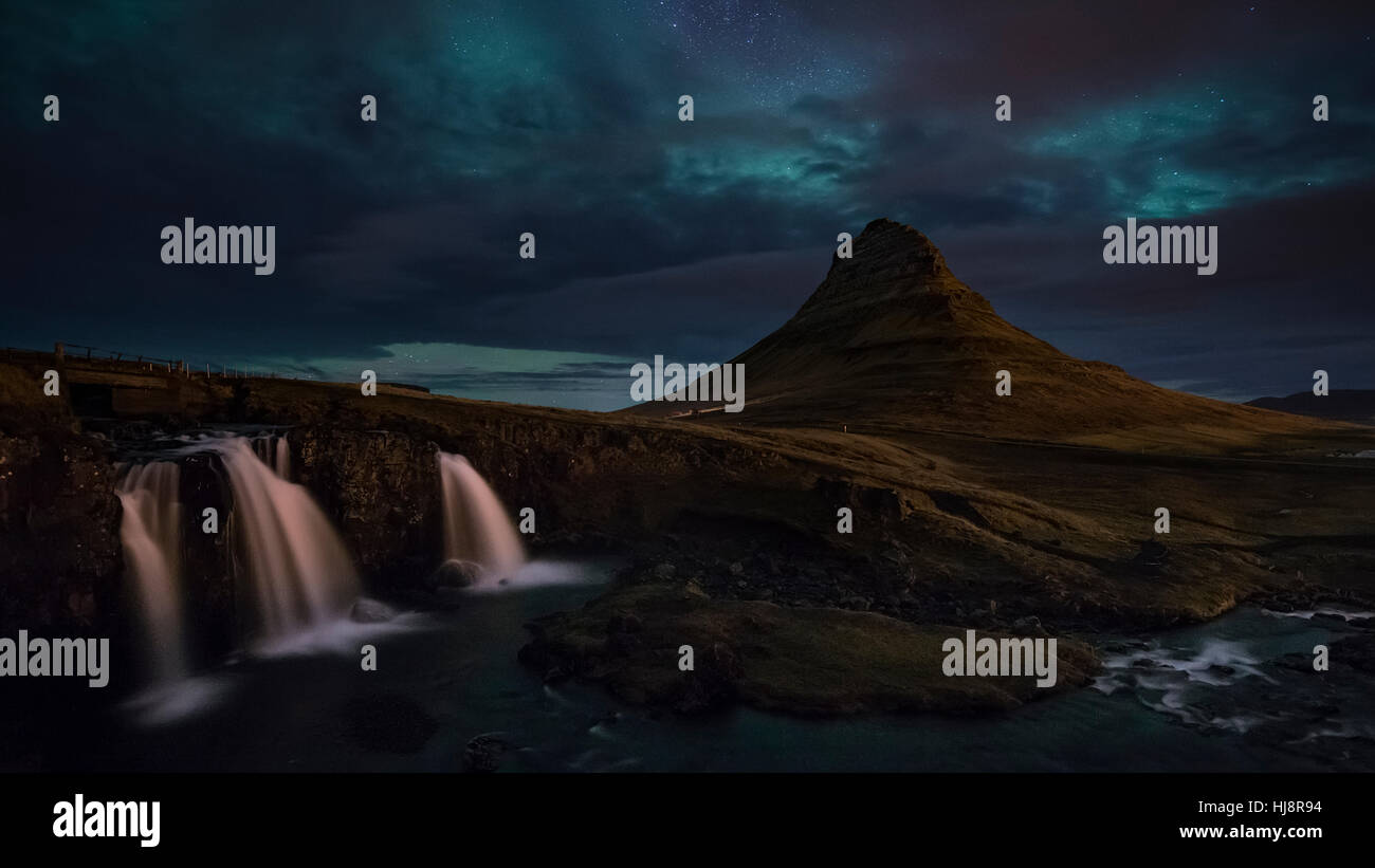 Luci del nord oltre Kirkjufellsfoss e Kirkjufell mountain, Islanda Foto Stock