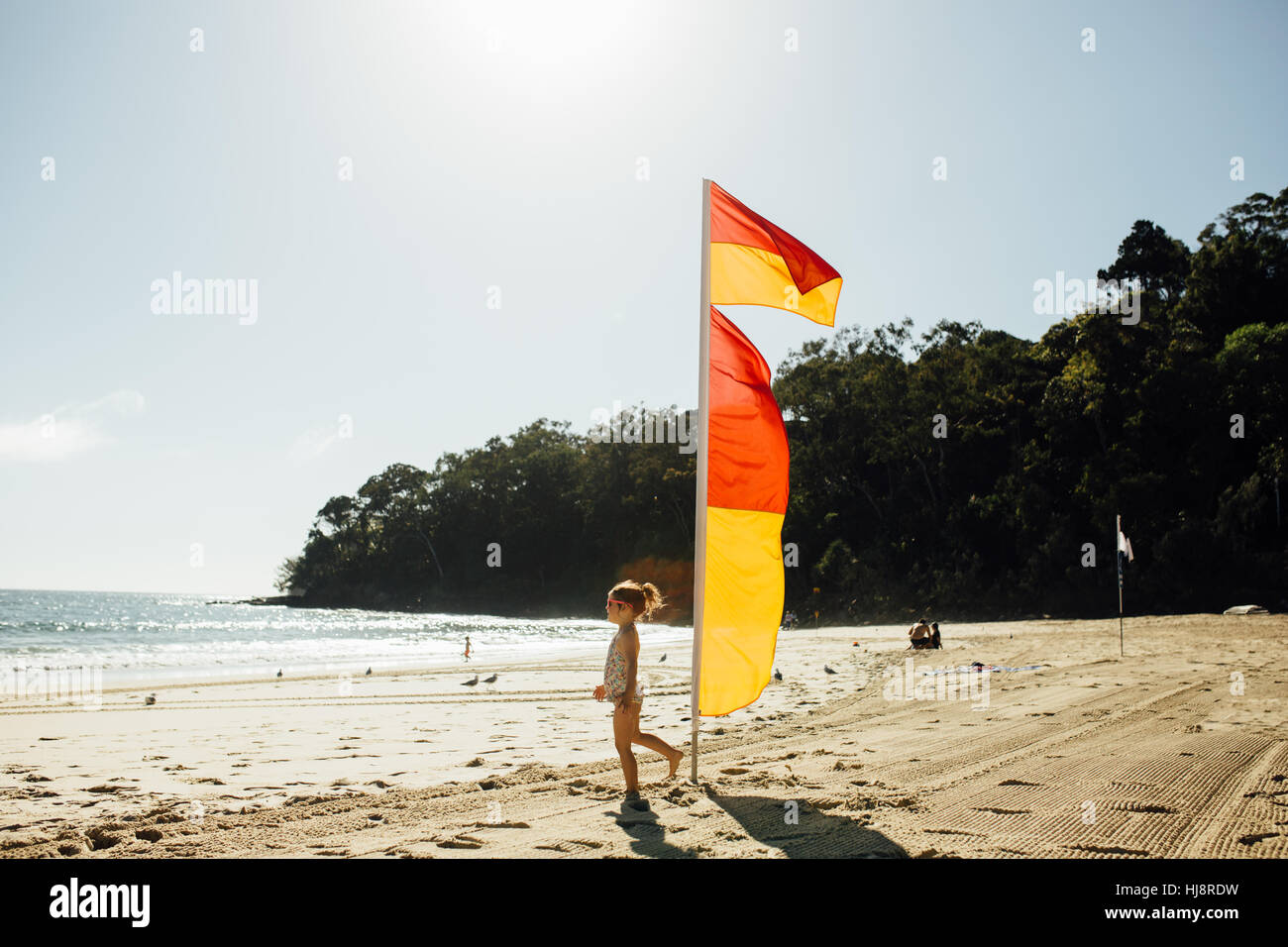 Ragazza sulla spiaggia a piedi da life saver bandiere Foto Stock Ragazza sulla spiaggia a piedi da life saver bandiere Foto Stock
