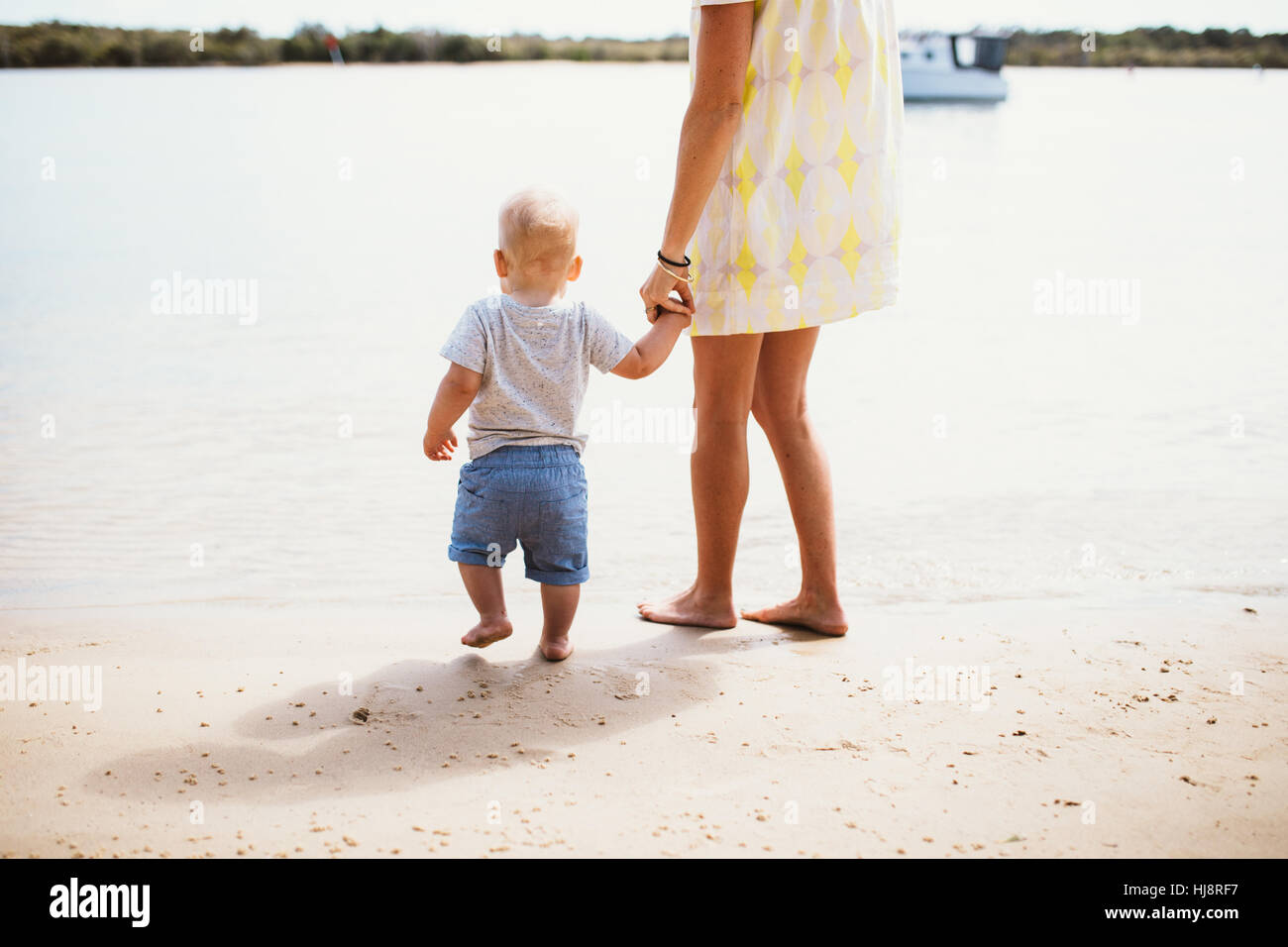 Madre e figlio presso la spiaggia in piedi al bordo d'acqua Foto Stock Madre e figlio presso la spiaggia in piedi al bordo d'acqua Foto Stock