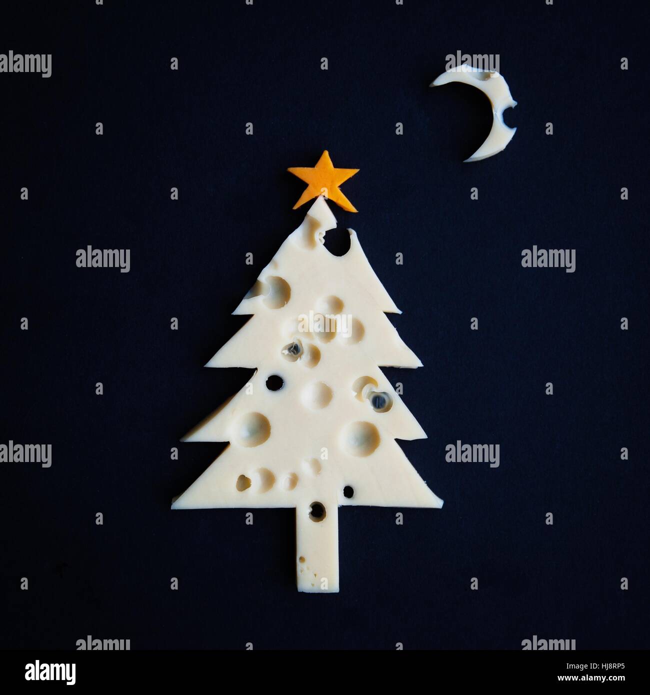 Conceptual albero di Natale fatto di formaggio con fori Foto Stock