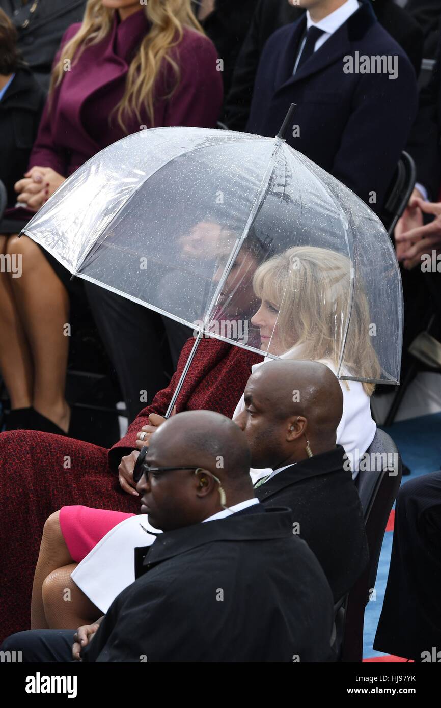 La First Lady Michelle Obama e il dottor Jill Biden sedersi sotto un ombrello durante una breve pioggia a sessantottesima Presidente cerimonia inaugurale su Capitol Hill Gennaio 20, 2017 a Washington, DC. Donald Trump divenne il quarantacinquesimo Presidente degli Stati Uniti nella cerimonia. Foto Stock