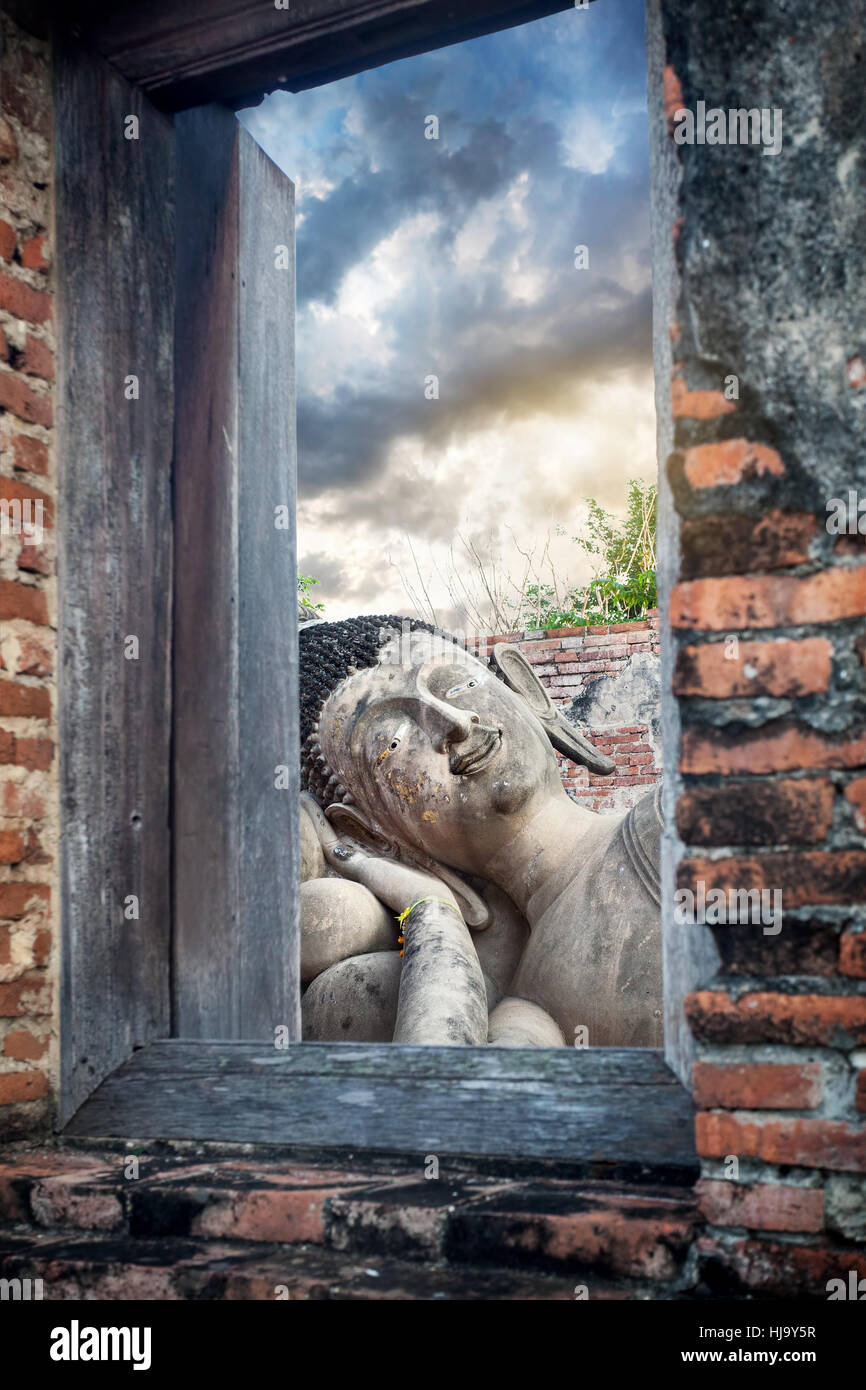 Sleeping statua del Buddha e rovinato tempio in Ayutthaya antica capitale della Thailandia Foto Stock