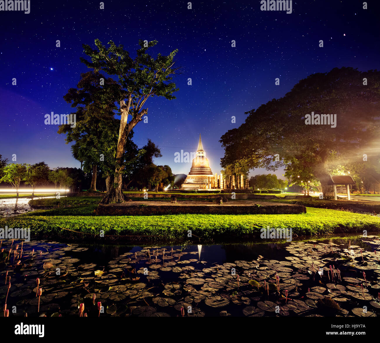 Luce che mostra in Stupa dorato tempio buddista in Sukhothai Historical Park, Thailandia Foto Stock
