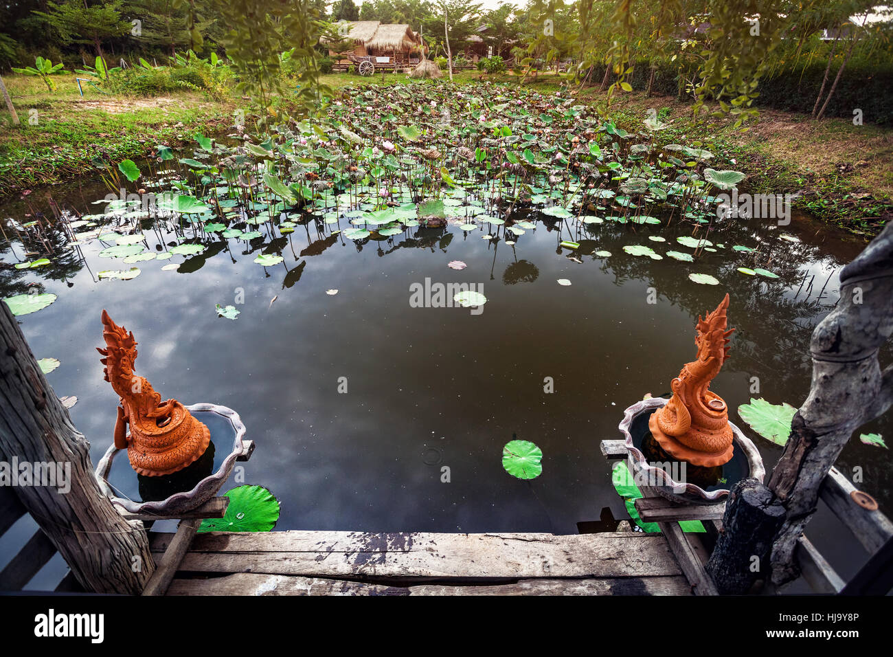 Bellissimo laghetto con Lotus e Dragon statue in Sukhothai resort, Thailandia Foto Stock