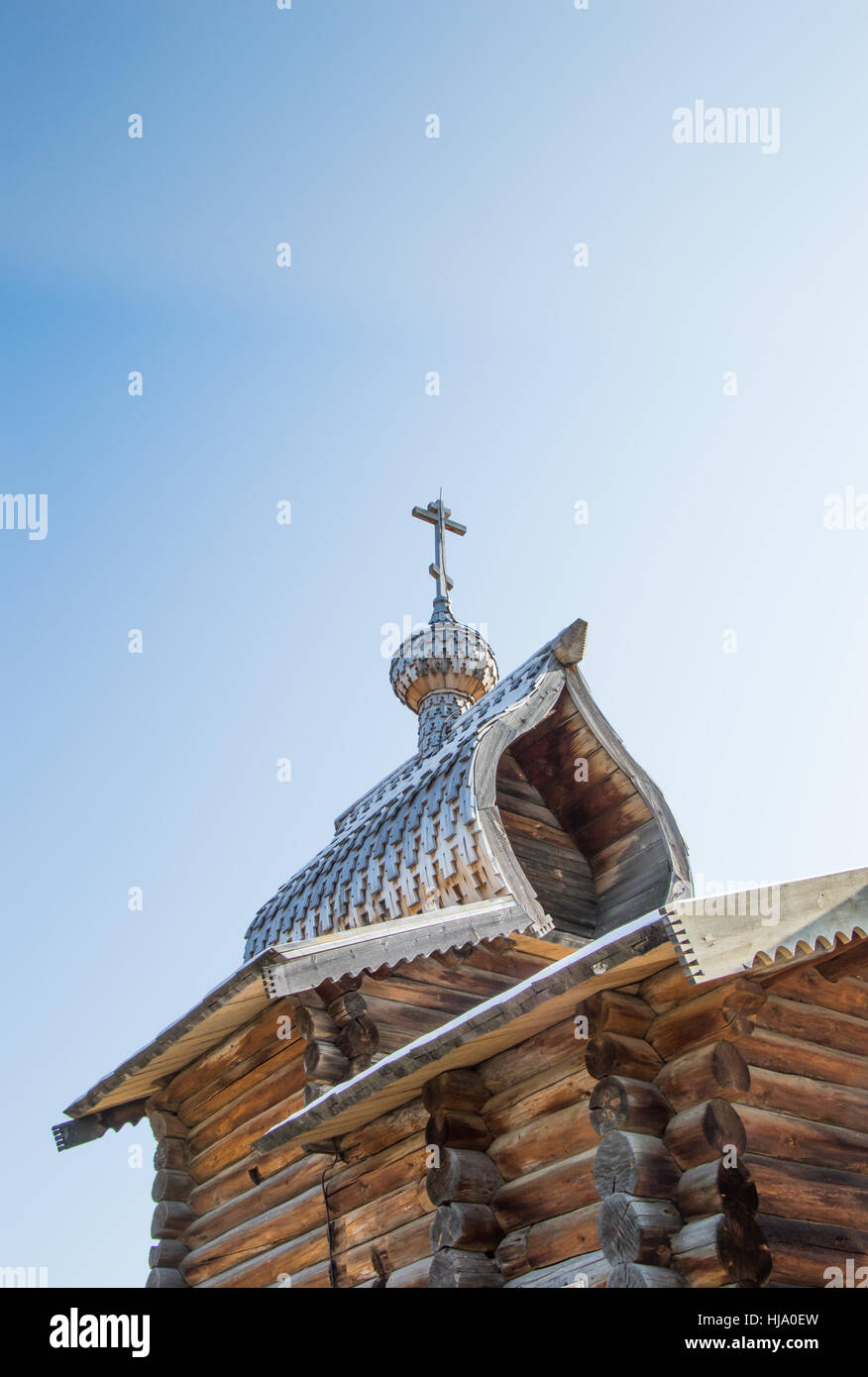 Una chiesa ortodossa russa fatte di tronchi con intricati scandole di legno sul tetto e cupola a cipolla. Anche con la croce di legno.tr Foto Stock