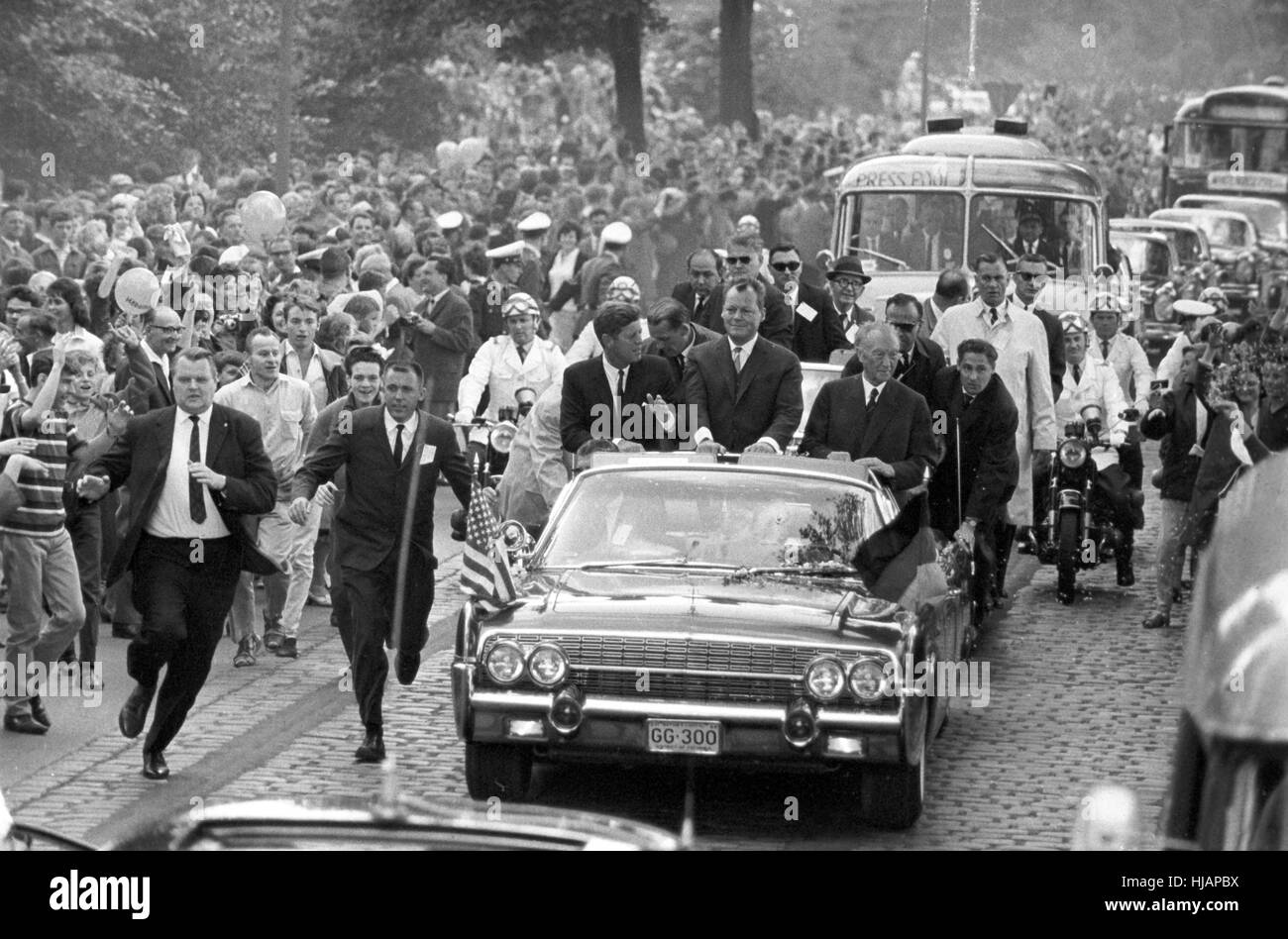 Il presidente statunitense John Fitzgerald Kennedy il 26 giugno 1963 a Berlino nell'aprire Lincoln Limousine con sindaco Willy Brandt (M) e il Cancelliere tedesco Konrad Adenauer (r). Foto Stock