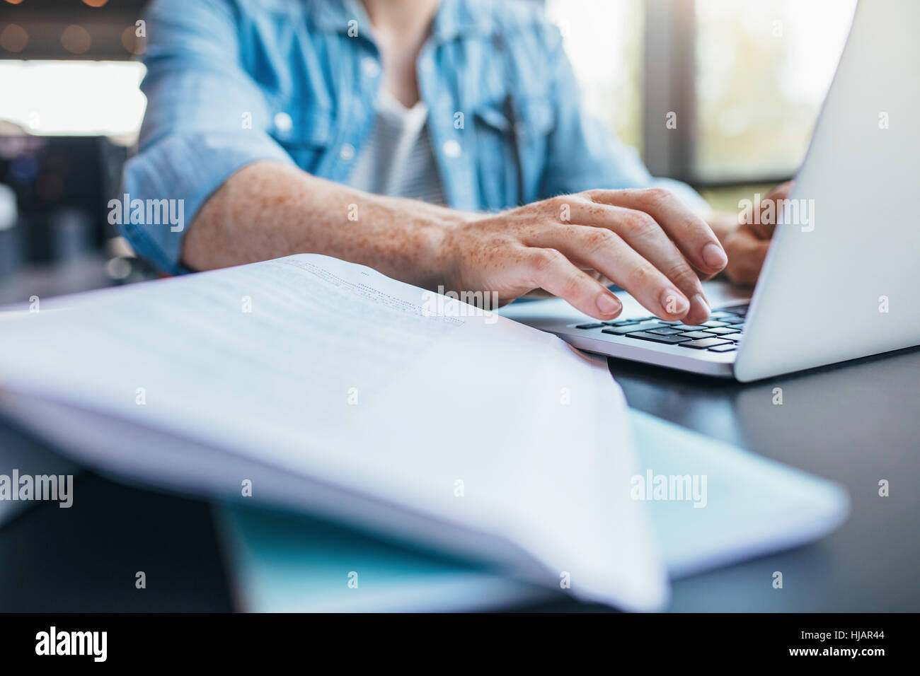 Close up man mano la digitazione su laptop. Maschio di studenti che lavorano su laptop in libreria Foto Stock