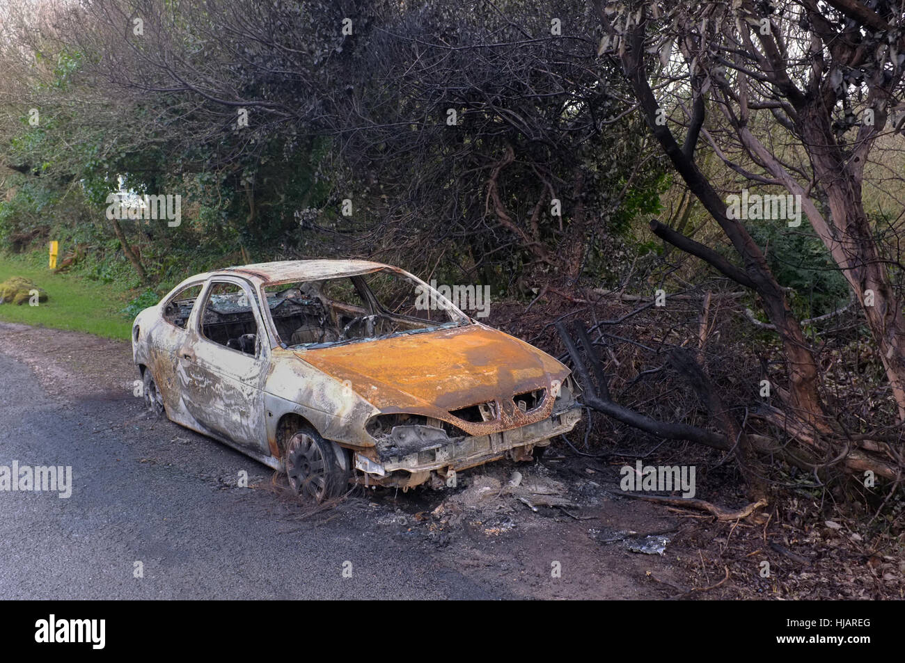 Un bruciato auto sulla strada appena fuori Sant Agnese, Cornwall. Foto Stock