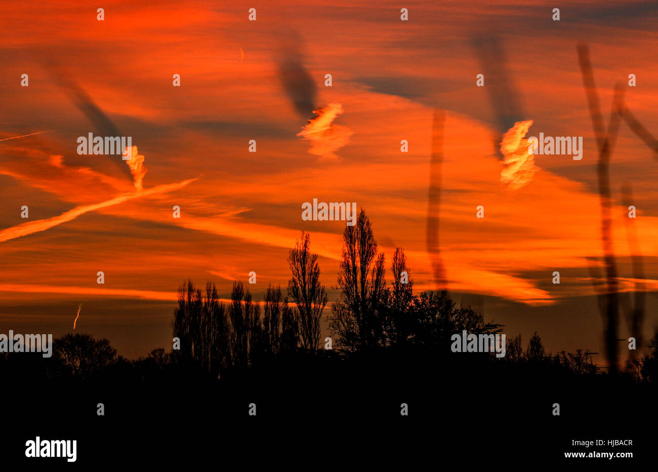 Una forma a spirale nuvole causando ombre su altre nubi in alba rossa Foto Stock