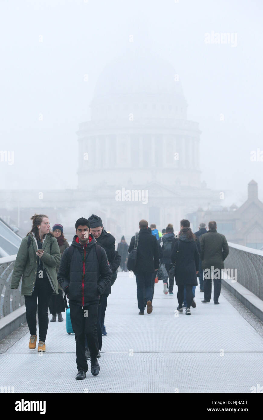 La gente a piedi attraverso Millennium Bridge di Londra verso la Cattedrale di St Paul e avvolto nella nebbia, come nebbia fitta causato interruzioni di viaggio attraverso il sud dell'Inghilterra, con migliaia di passeggeri aerei rivolta verso le cancellazioni e ritardi. Foto Stock