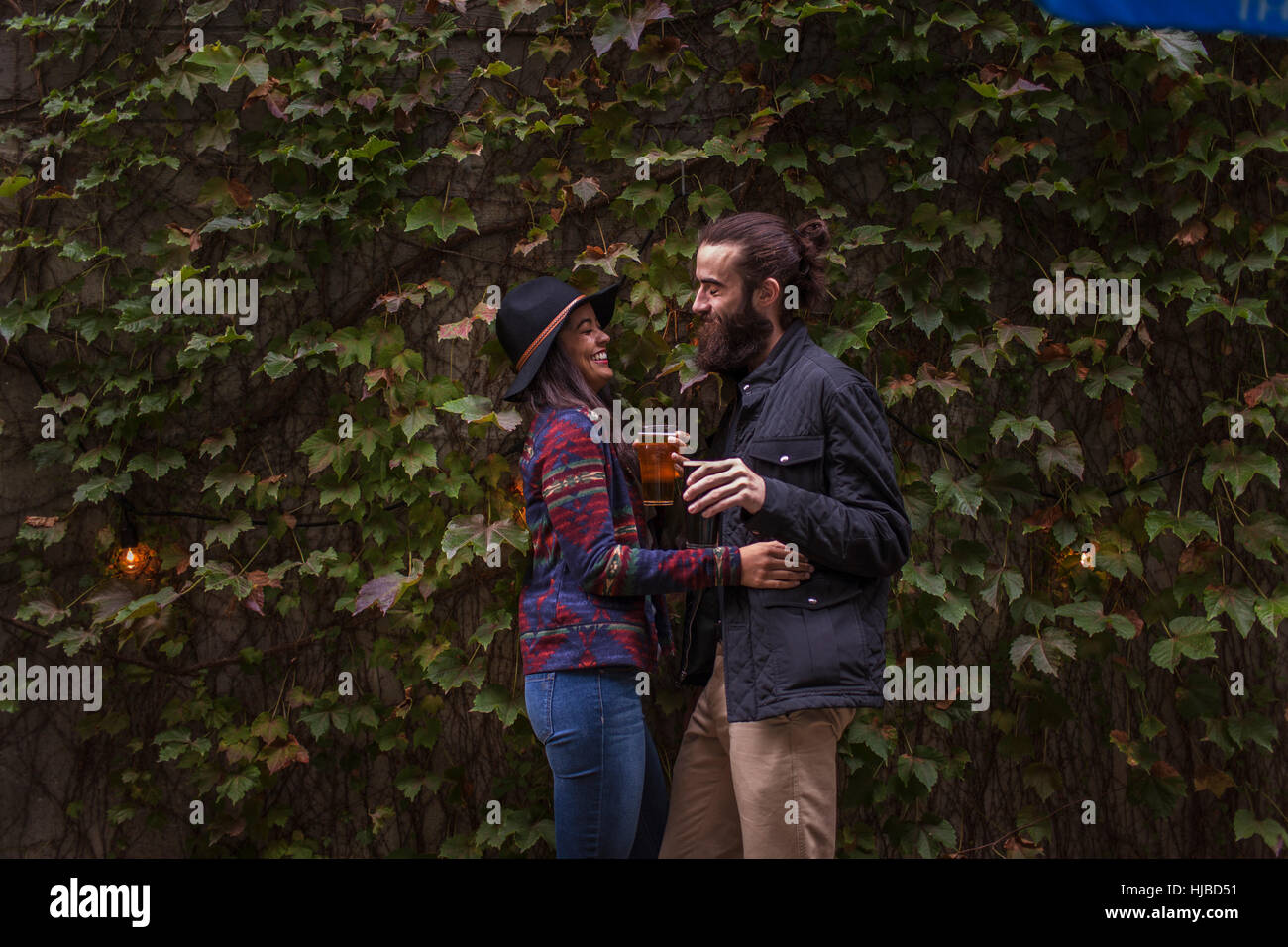 Coppia giovane ridendo nel giardino della birra in serata, Brooklyn, New York, Stati Uniti d'America Foto Stock