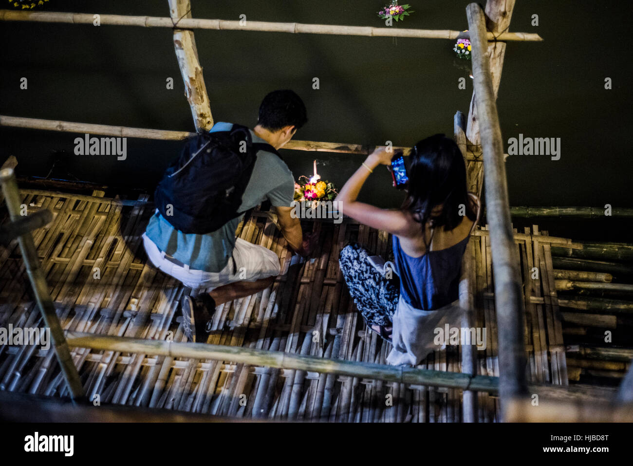 Giovane uomo e donna a Loy Krathong festa delle lanterne, rilasciando lanterna oscillante verso il basso del fiume Ping, Chiang Mai, Thailandia Foto Stock