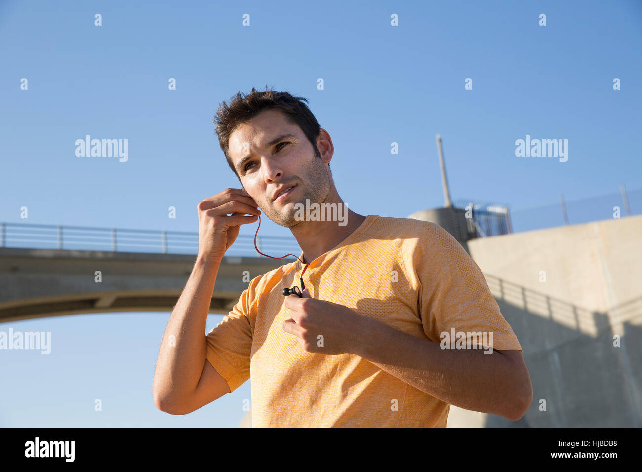 Atleta maschio mettendo su auricolari, Van Nuys, CALIFORNIA, STATI UNITI D'AMERICA Foto Stock