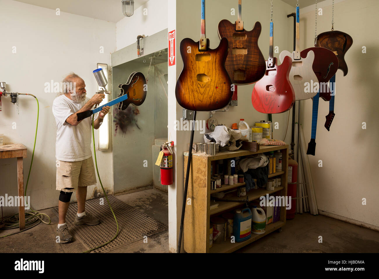 Liutaio in officina con la pistola a spruzzo per verniciatura di chitarra  Foto stock - Alamy
