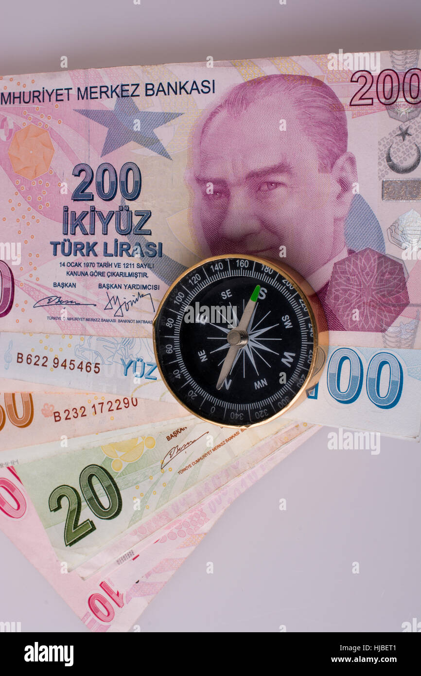 La Lira turca banconote dal lato di una bussola su sfondo bianco Foto Stock