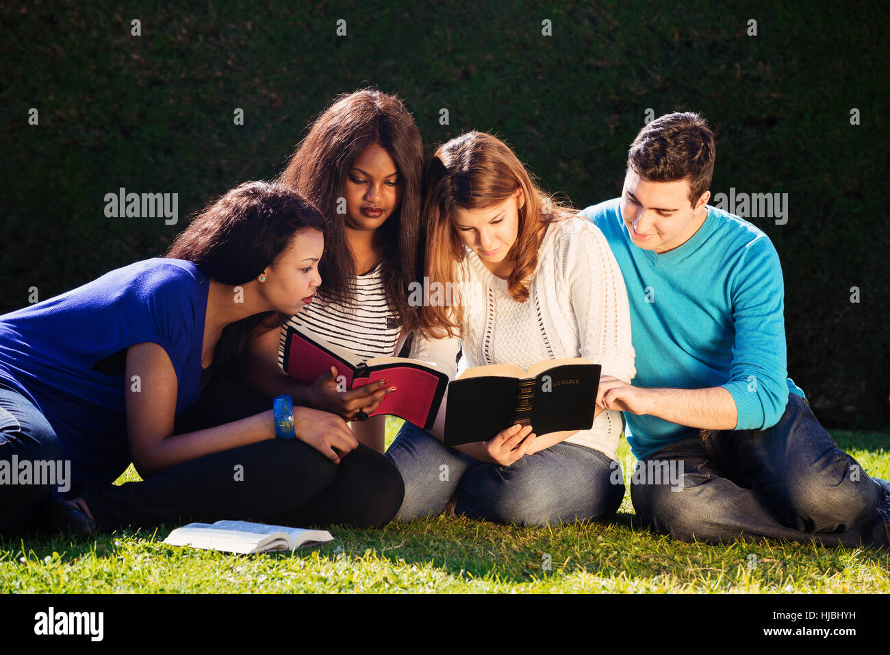 Un gruppo di giovani che studiano insieme la Bibbia Foto Stock