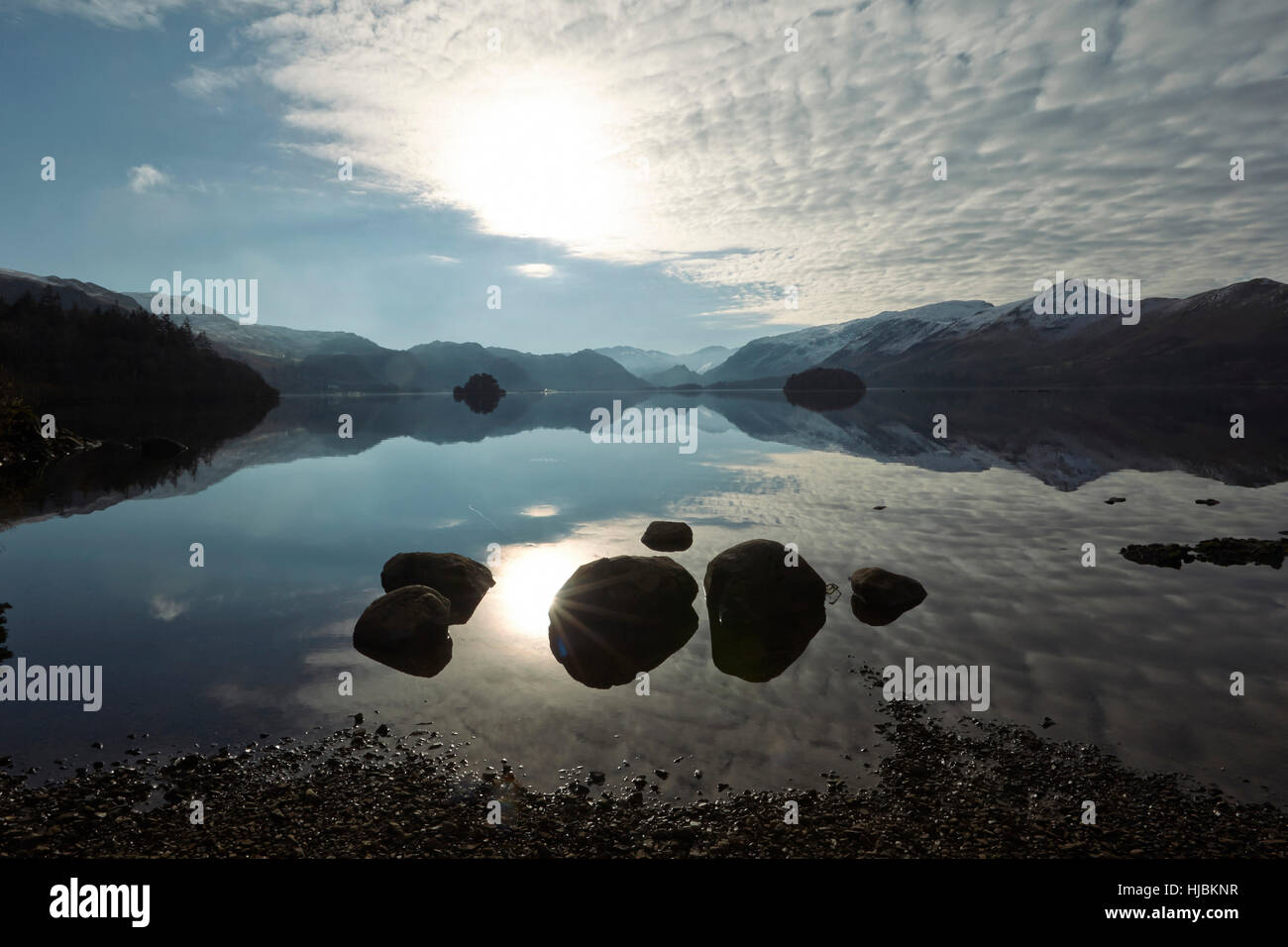 Montagne di rocce e alberi riflessa nella calma superficie di Derwent Water, Keswick, Cumbria, Lake District, England Regno Unito Foto Stock