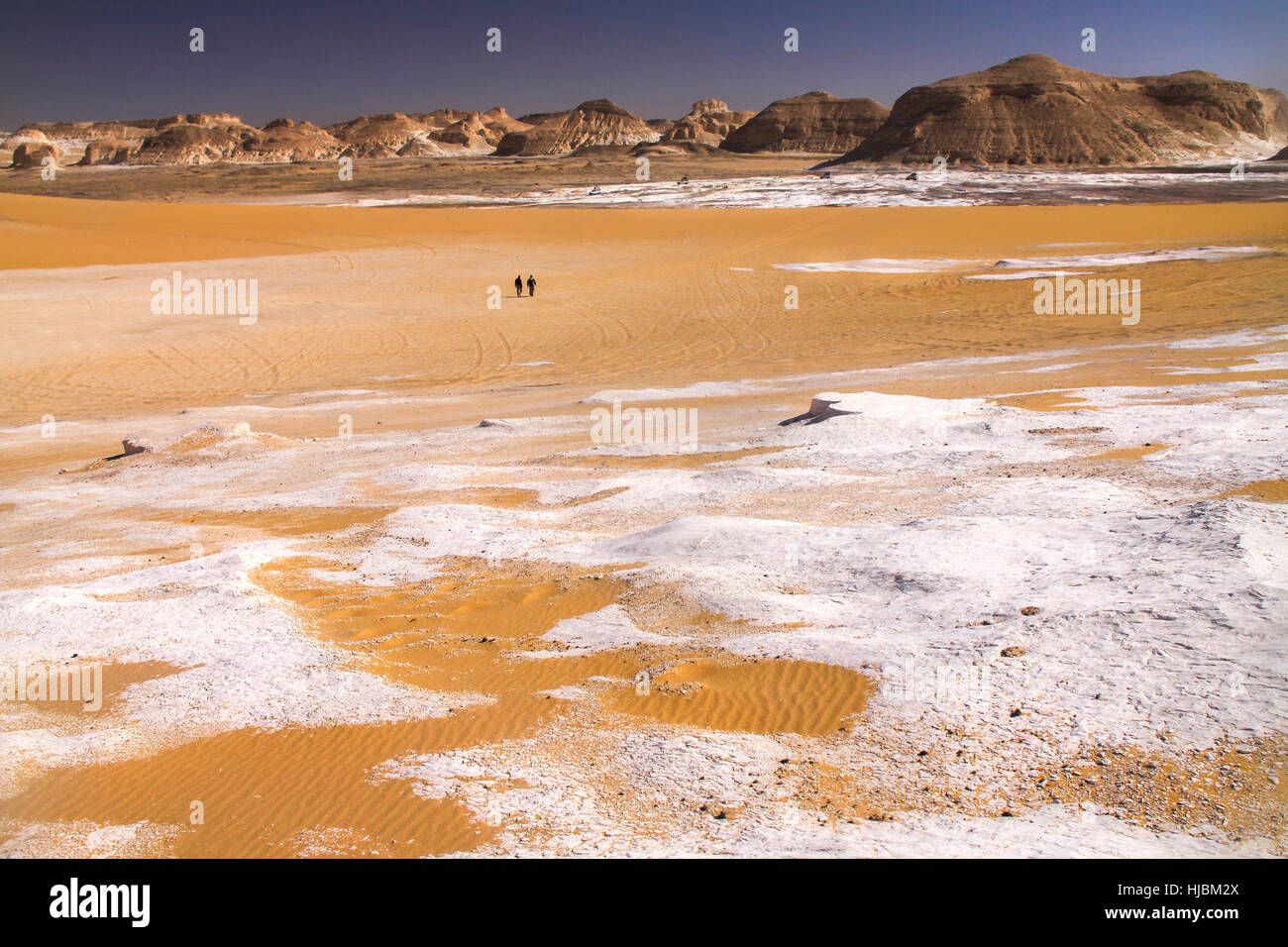 Persone isolate camminando nel Parco Nazionale del deserto Bianco Egiziano con il paesaggio delle formazioni rocciose di arenaria Bianca Foto Stock