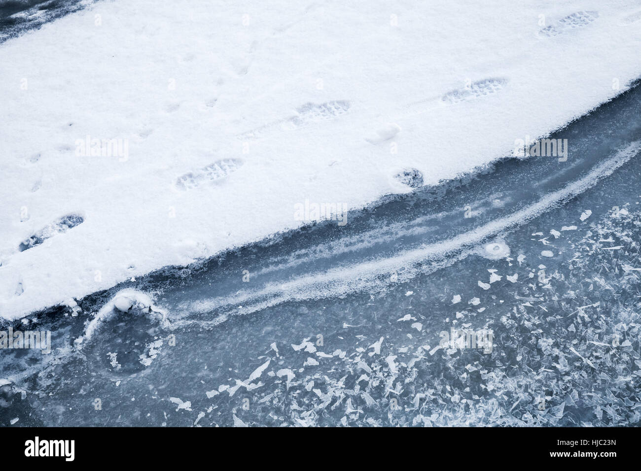 Coperte di ghiaccio con spettacolo sul fiume congelato. Footprints va oltre il cumulo di neve costiera Foto Stock