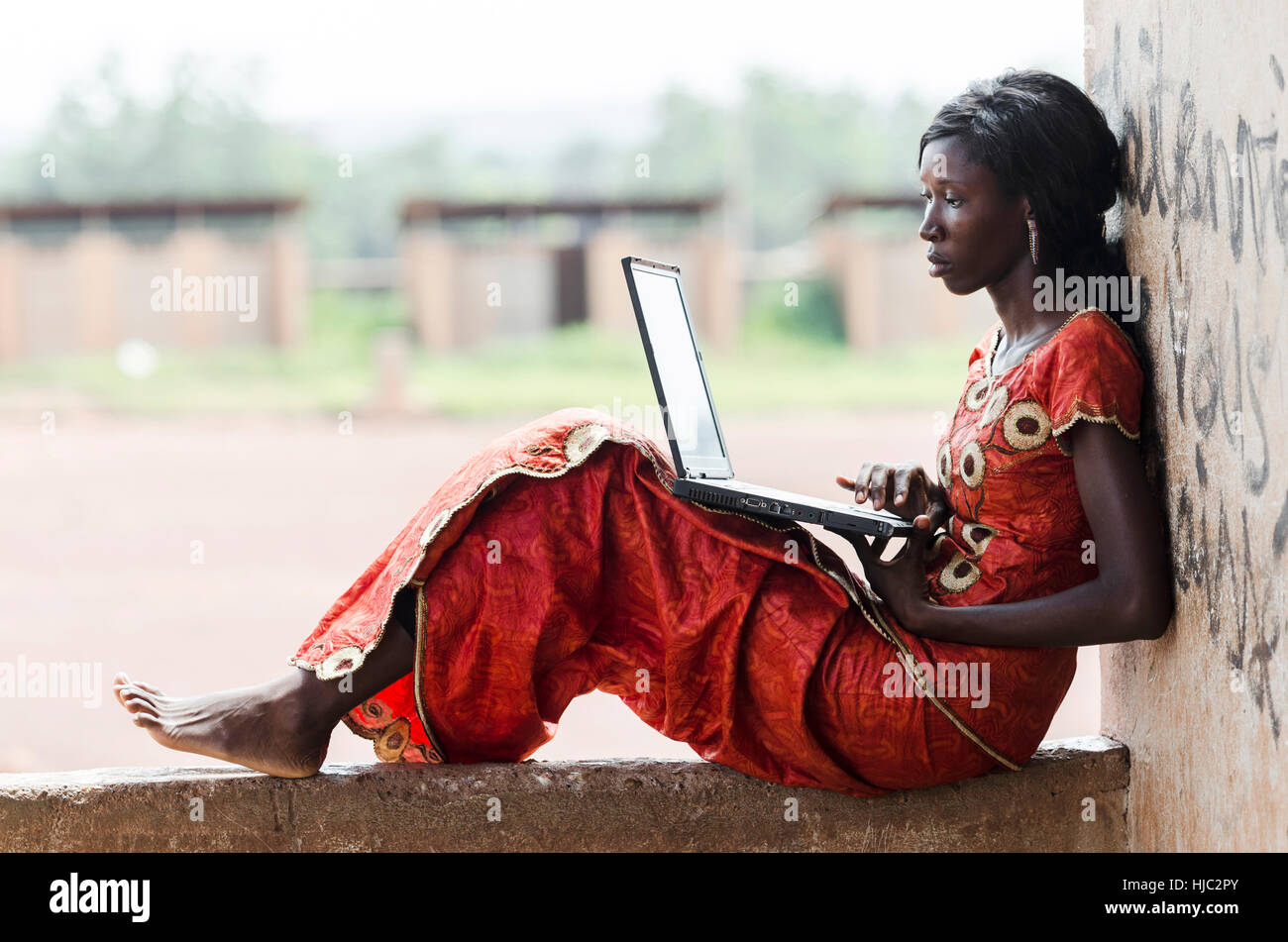 A piedi nudi modello africana lavorando sul suo computer portatile simbolo di Business Foto Stock