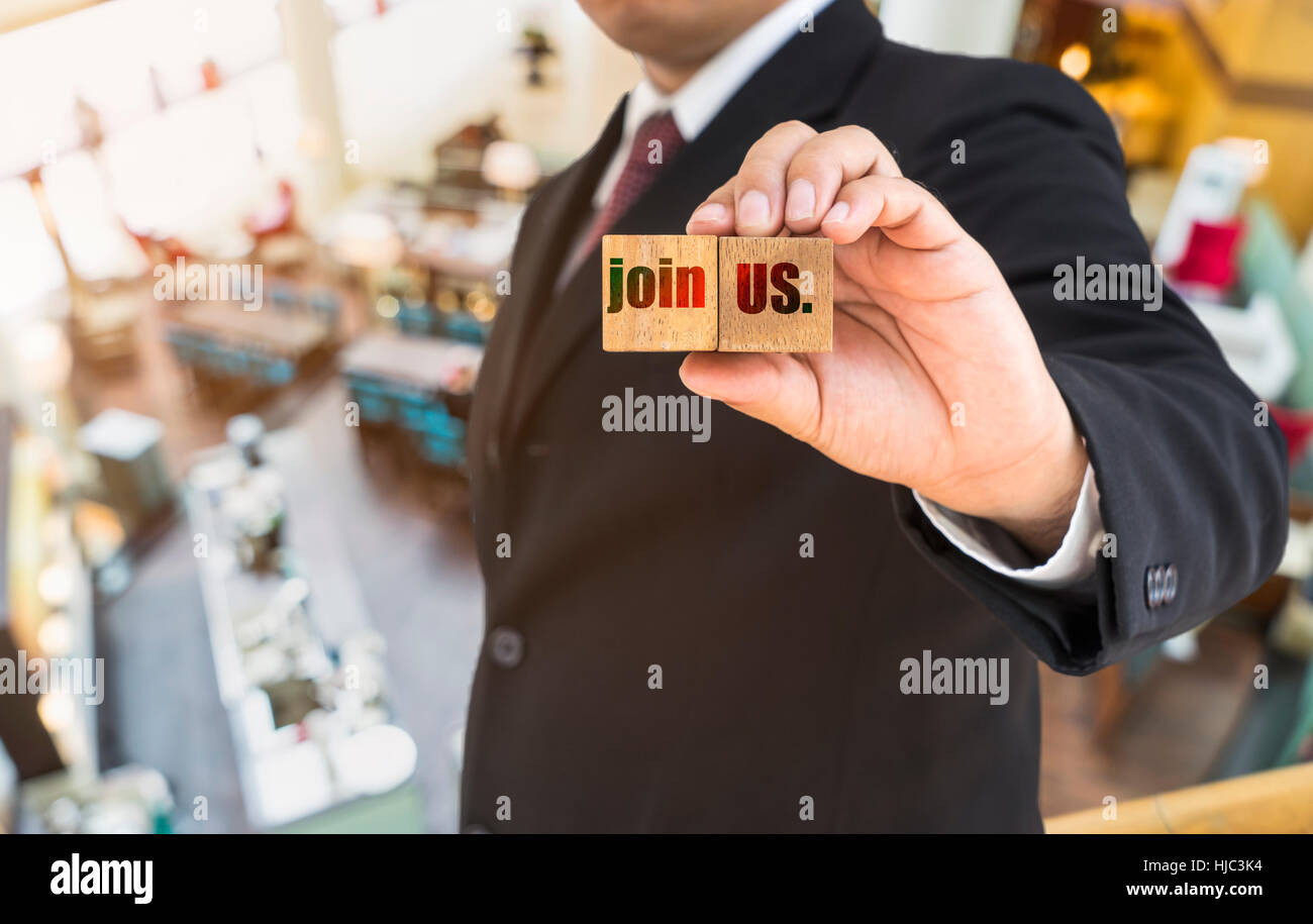 Imprenditore astratto visualizza parola unisciti a noi su blocchi di legno e ristorante di sfocatura sullo sfondo - possono essere utilizzate per la visualizzazione o montaggi sul prodotto Foto Stock