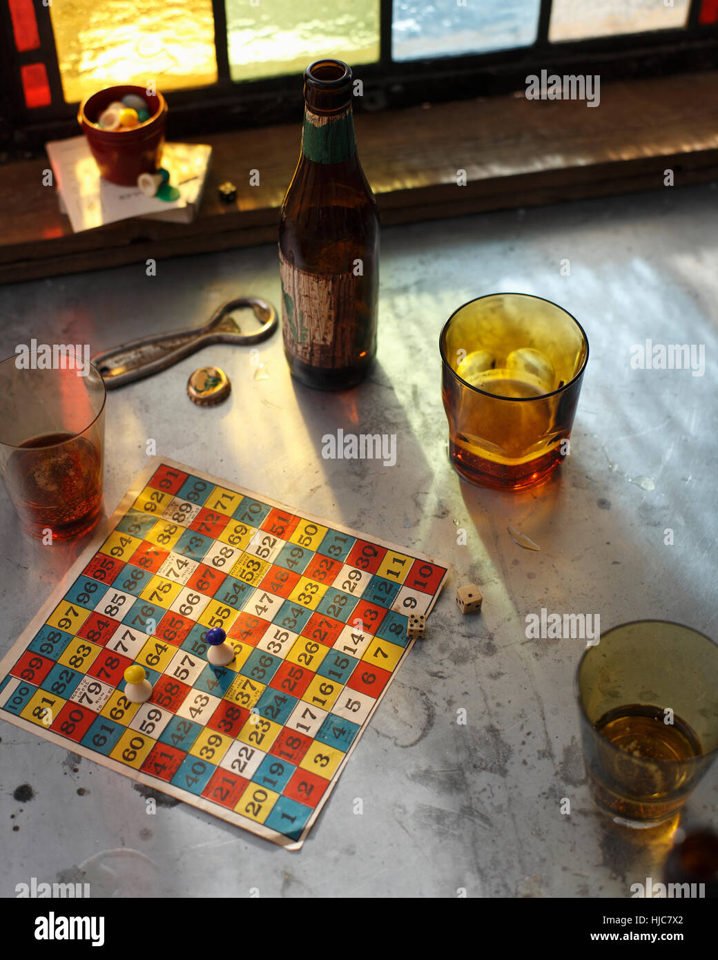 Bottiglia di birra e bicchieri con gioco di bordo sulla tabella pub Foto Stock