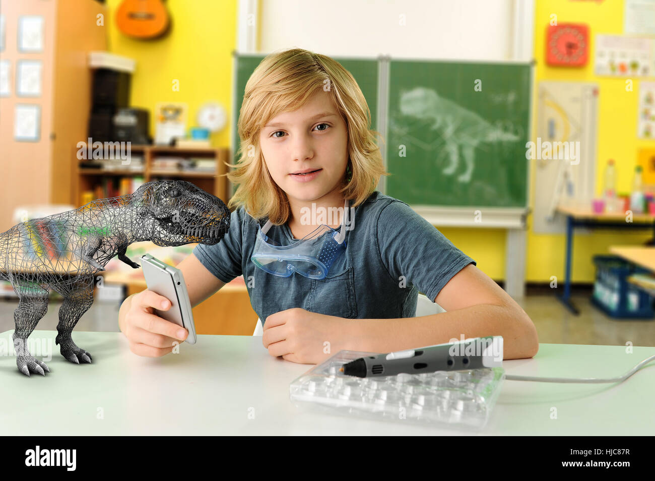 Ritratto di ragazzo con computer palmari e modello 3D del Tyrannosaurus rex Foto Stock