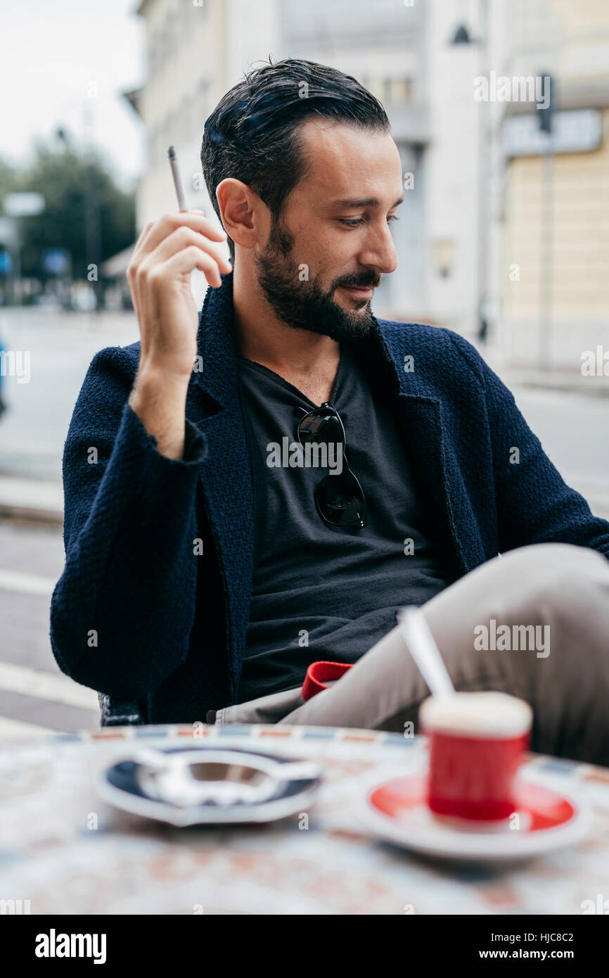 Metà uomo adulto Sigaretta fumare al cafè sul marciapiede Foto Stock