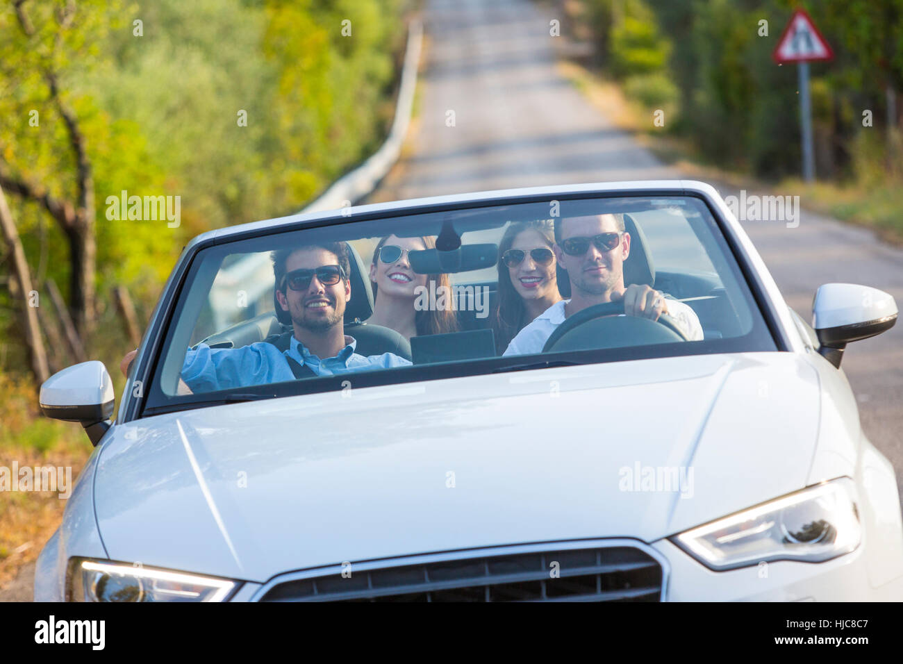 Quattro amici adulti guida su strada rurale Nel convertibile, Maiorca, SPAGNA Foto Stock