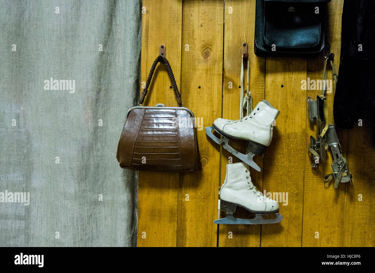 Vintage pattini da ghiaccio e borsa appesa da parete in legno Foto Stock