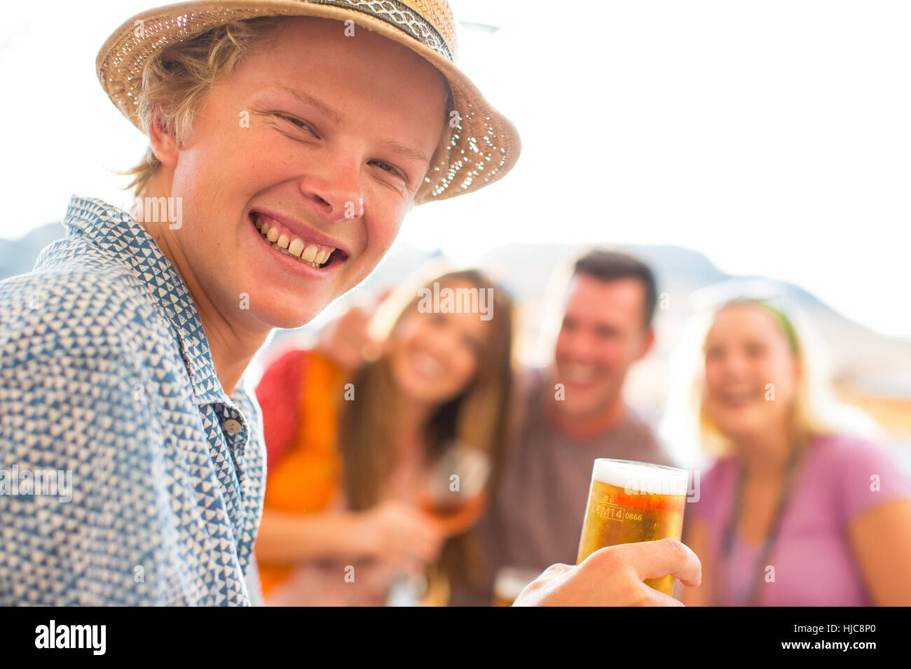 Ritratto di giovane uomo con amici adulti a waterfront restaurant, Maiorca, SPAGNA Foto Stock