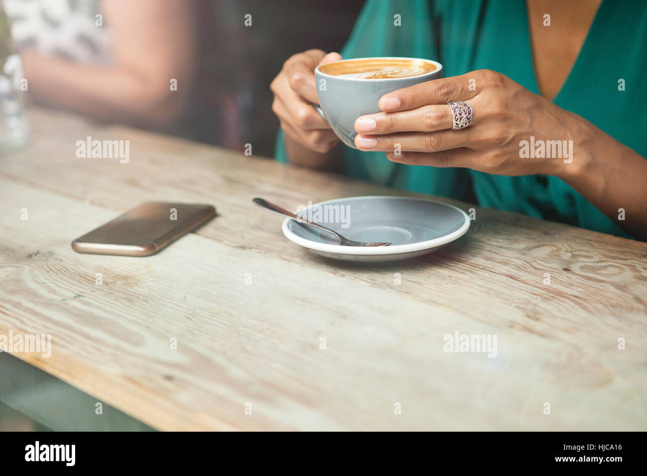 Donna di mani tazza di caffè nella caffetteria finestra Foto Stock