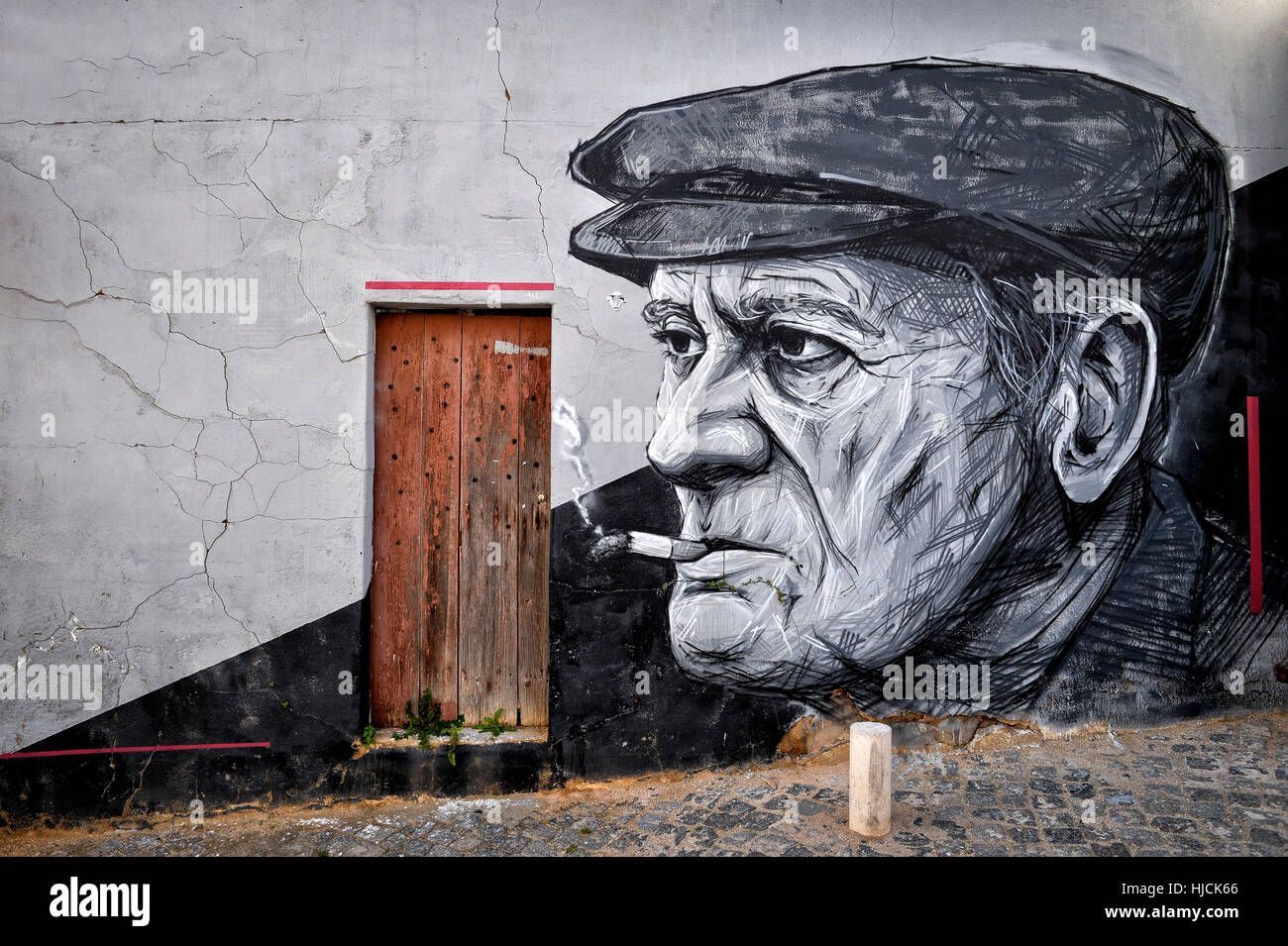 Il vecchio uomo di fumare una sigaretta, Arte di strada Foto Stock