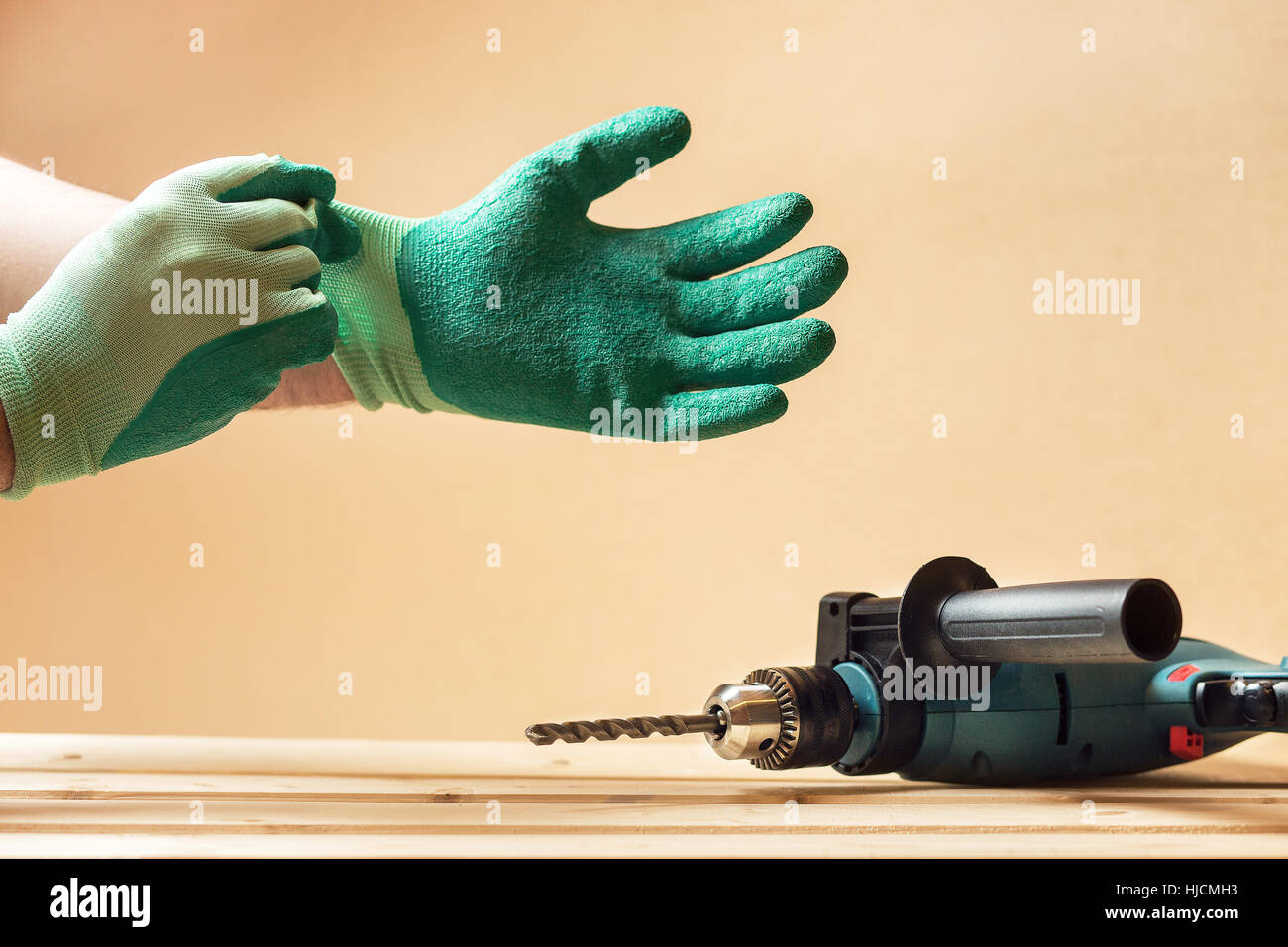 L'uomo mette in guanti di protezione prima della foratura Foto Stock