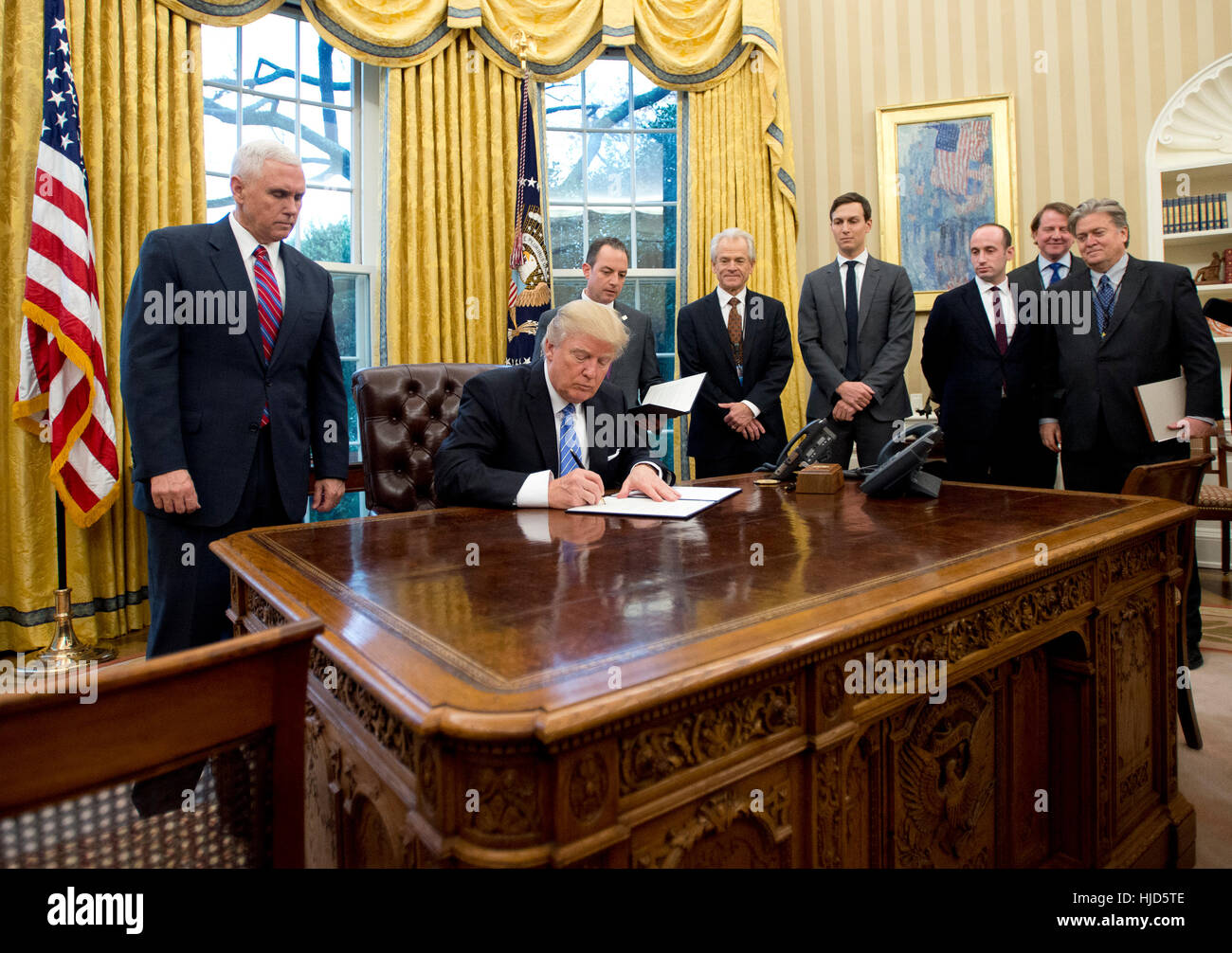 Washington DC, Stati Uniti d'America. 23 gennaio, 2017. Il Presidente degli Stati Uniti, Donald Trump segni il primo dei tre ordini esecutivi nell'Ufficio Ovale della Casa Bianca di Washington, DC il lunedì, 23 gennaio 2017. Hanno interessato il ritiro degli Stati Uniti dal partenariato Trans-Pacific (TPP), un governo USA congelamento delle assunzioni per tutti i reparti ma il militare, e "Messico City' che vieta il finanziamento federale di aborti all'estero. Credito: MediaPunch Inc/Alamy Live News Foto Stock