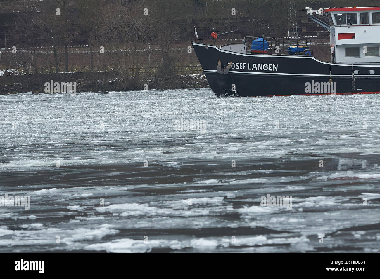 Oberfell, Germania. 24 gen 2017. L'ice breaker Josef Langen mantiene un percorso chiaro sul fiume Mosella vicino Oberfell, Germania, 24 gennaio 2017. La permanente il gelo ha causato il ghiaccio per formare sulla superficie. Foto: Thomas Frey/dpa/Alamy Live News Foto Stock