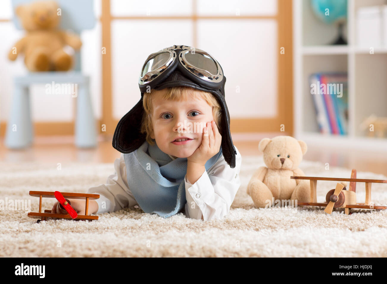 Ritratto di un bambino ragazzo giocando con aereo in legno e sognare da aviatore Foto Stock
