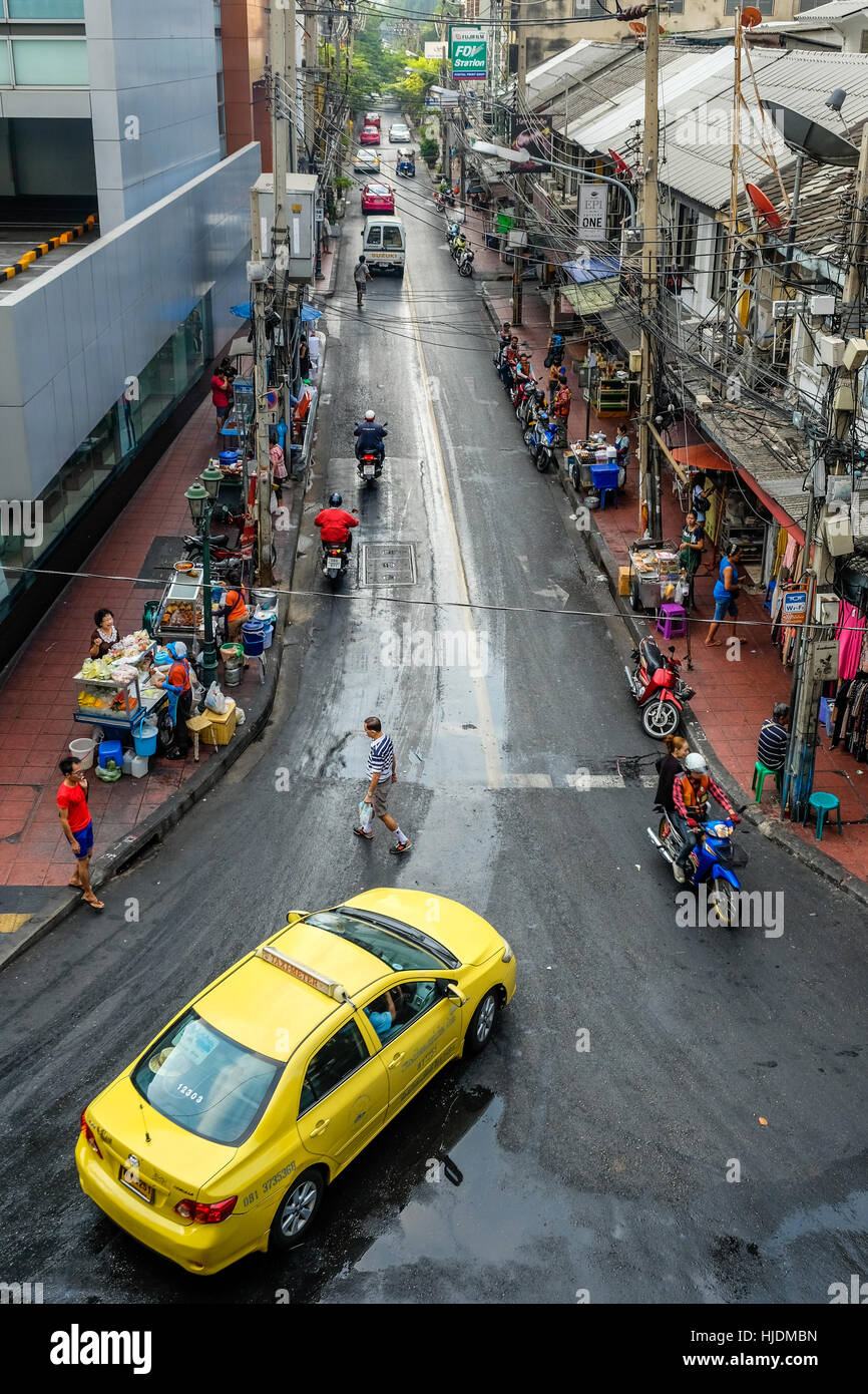 Yellow taxi guida lungo una strada di Bangkok Foto Stock