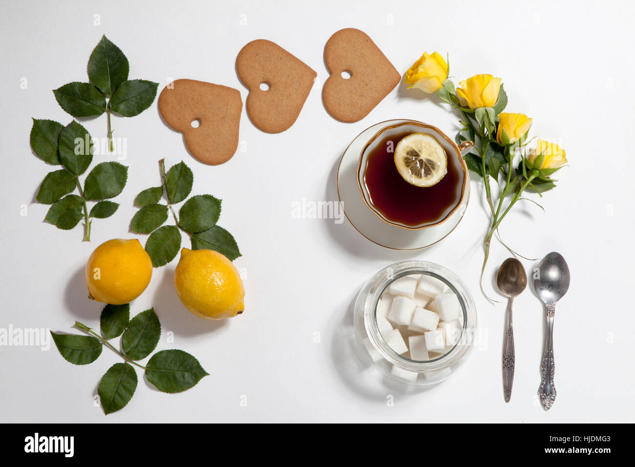 Ornamento di limoni, cookie e foglie di rosa su sfondo bianco. La ricetta del pan di zenzero Foto Stock