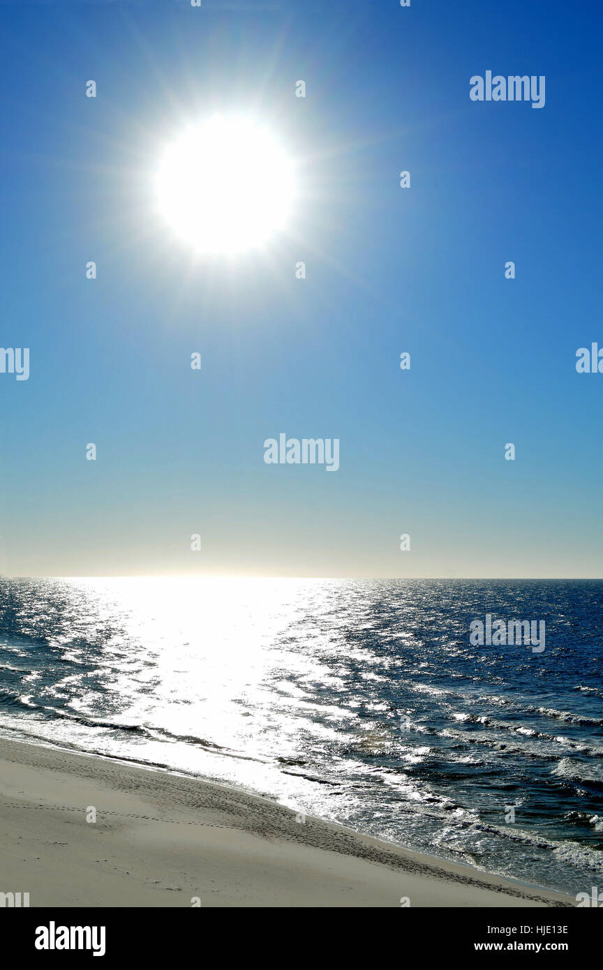 Sun luccicante sull'oceano,spiaggia di sabbia bianca e un luminoso cielo blu. Il sole è in forma di un'incudine a Perdido Key. Foto Stock